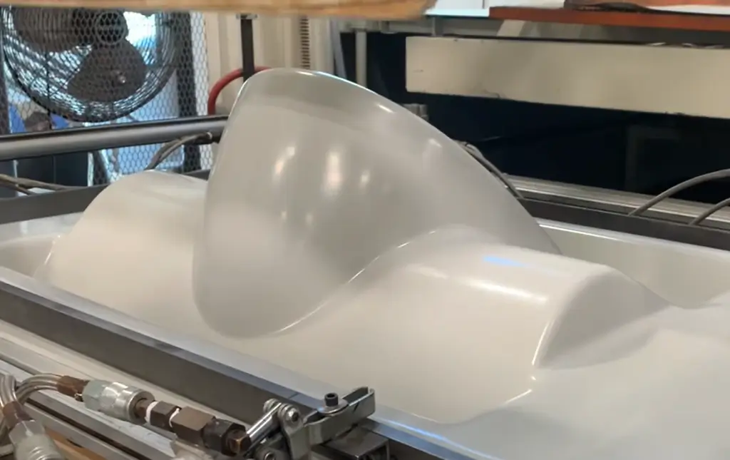 Plastic mold forming in industrial machine.